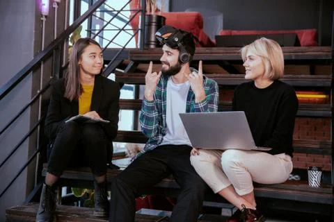 Attractive group of young friends on the library enjoying their free time using Stock Photos