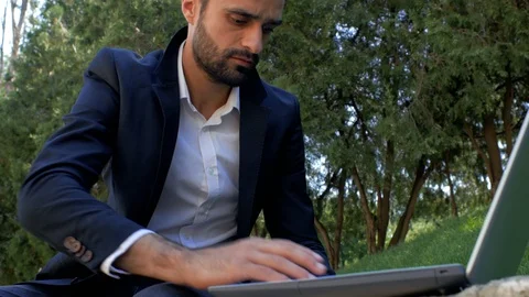 Attractive guy with a beard  works on a laptop, drinks coffee a disposable cup Stock Footage 113923249