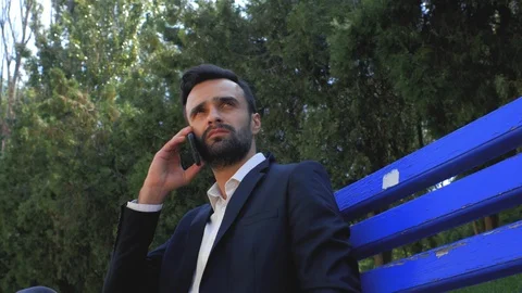 Attractive guy businessman with a beard is waiting for a phone call. 4k Stock Footage 113898547