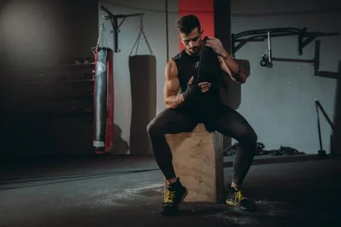 Attractive guy concentrated using a professional bandages wraps his hands Stock Photos