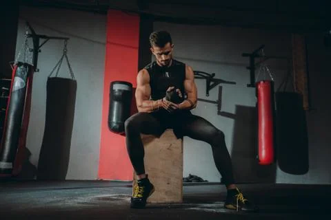 Attractive guy concentrated using a professional bandages wraps his hands Stock Photos