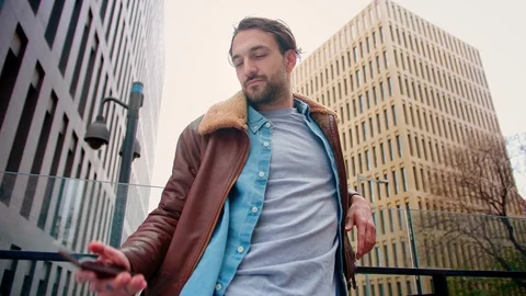 Attractive guy gets smartphone from pocket and receiving new pleasant SMS Stock Footage 115910343