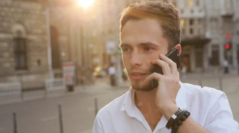 Attractive guy have a businness talk on the phone. Man seriously speaking on Stock Footage 62313334