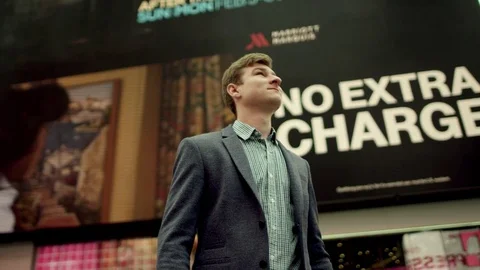 Attractive guy is joyfully looking around on famous TImes Square Stock Footage 79485684