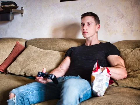 Attractive guy playing videogames with joystick in hand Stock Photos