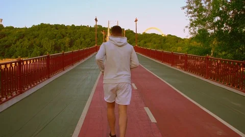 Attractive guy is running over the bridge Stock Footage 92020008