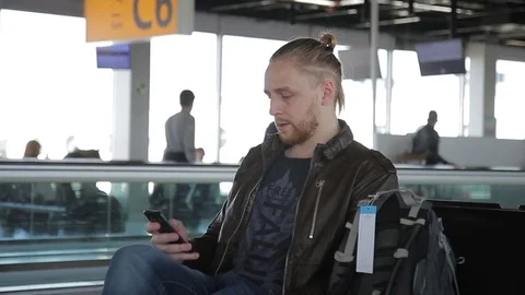 Attractive guy sitting in hall of station international airport Video stock 83111580