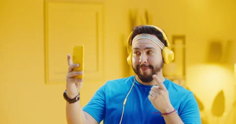 Attractive handsome bearded young man in casual t-shirt having fun taking Stock Footage 165869955