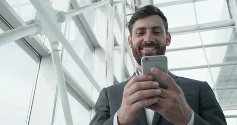 Attractive Handsome Office Manager working on the Smartphone in hall inside Stock Footage 123461149