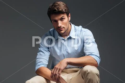 Attractive handsome serious man sitting and looking at camera Stock Photos
