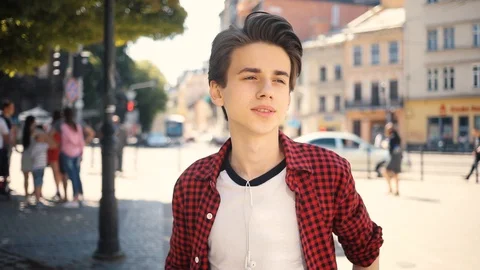 Attractive happy smiling boy using mobile phone look around walk in city guy Stock Footage 92051311