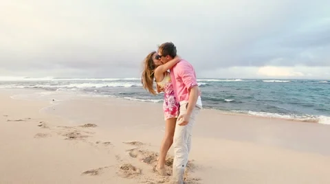 Attractive healthy couple having fun being together running on beach Stock Footage 58166409