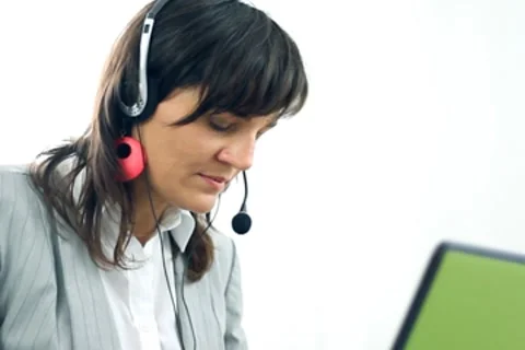 Attractive helpdesk consultant with headache Stockbeeldmateriaal 7743799