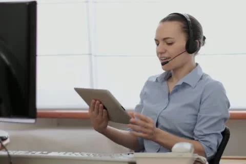Attractive helpdesk consultant working on tablet computer NTSC Stock Footage 22021570