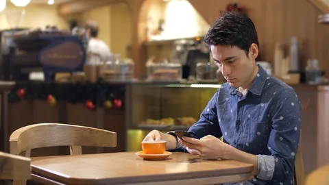 Attractive hispanic latin young man sitting in coffee shop using smartphone Vídeo Stock 101068791