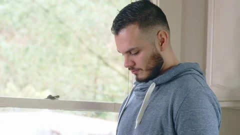Attractive hispanic millenial man in bright morning kitchen using smartphone Stock Footage 84480751