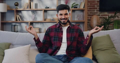 Attractive indian man doing yoga in lotus position and smiling looking at camera Stock Footage 225539452