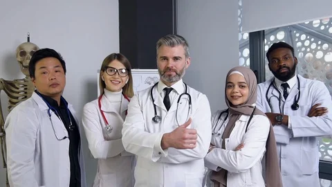 Attractive joyful high-skilled mixed race medical stuff posing on camera and Video stock 122640327