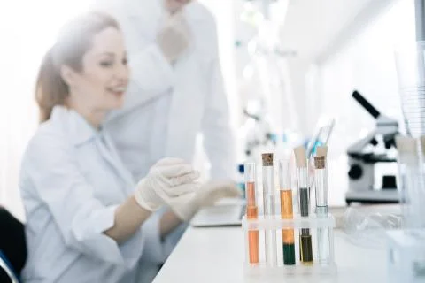 Attractive lab assistant pointing at test tubes Foto stock