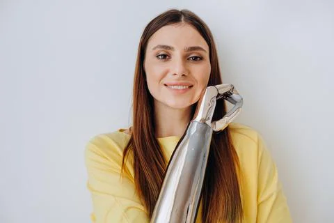 Attractive lady with bionic prosthesis arm looks into camera Foto stock