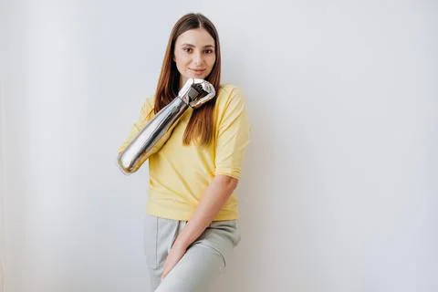 Attractive lady with bionic prosthesis arm looks into camera Foto stock