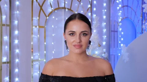 Attractive lady looking at camera against glowing christmas lights. Stock Footage 124037360