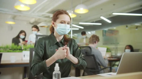 An attractive lady is sanitizing her hands and working Stock Footage 159353814