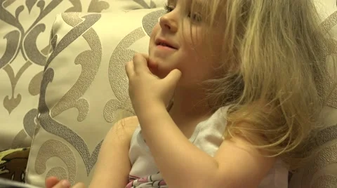 Attractive Little Gitl Scratching She's Chin. 4K UltraHD, UHD Stockbeeldmateriaal 61100101