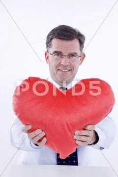 Attractive man, 50+, holding a plush heart Stock Photos
