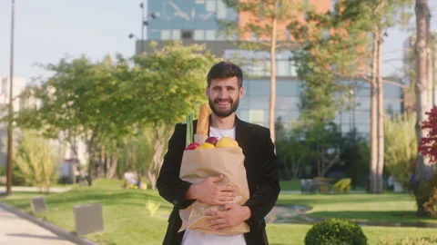 Attractive man after shop posing happy with a eco bag full with food he standing Stock Footage 164865736