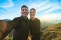 The attractive man and a woman taking a selfie on the mountain background Photo