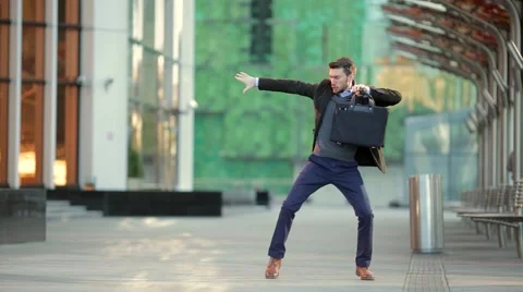 Attractive man with a beard and briefcase dancing in the street Video stock 68400034