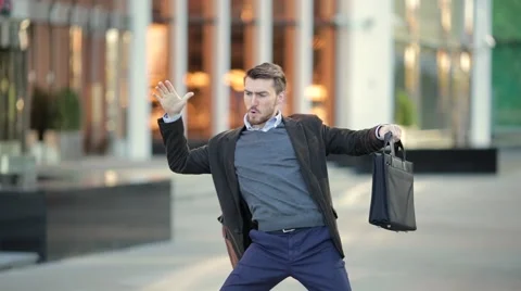 Attractive man with a beard and briefcase dancing in the street Stock Footage 68400132