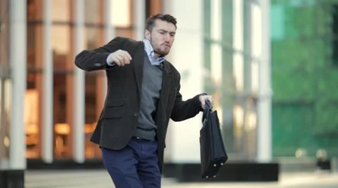 Attractive man with a beard and briefcase dancing in the street Stock Footage 68400139