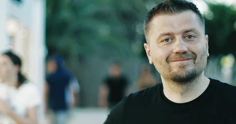 Attractive man with a beard is looking at the camera and smiling. Stock Footage 99449060