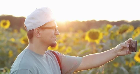 Attractive man with a beard making selfie in a large field with yellow Stock Footage 101601207