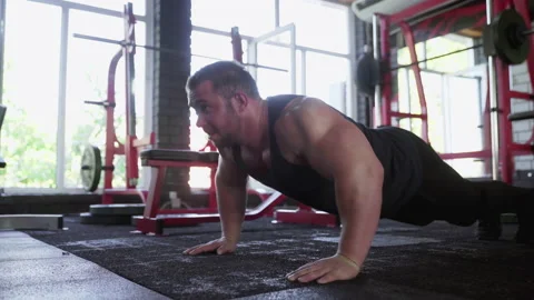 An attractive man bodybuilder performing Push-up exercise at gym Stock Footage 142667746