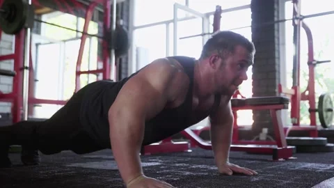 An attractive man bodybuilder performing Push-up exercise at gym Stock Footage 143521332