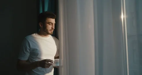 Attractive man with dark beard and hair is enjoying the first cup of coffee Stock Footage 93352664