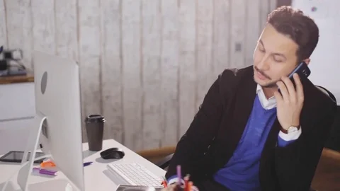 Attractive man discussing the project by phone in the office Stock Footage 81121053