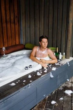 An attractive man does a hydro massage in an outdoor Jacuzzi. Maldives Foto stock