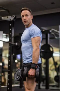 Attractive man doing lunges step-ups with heavy dumbbell. Stock Photos
