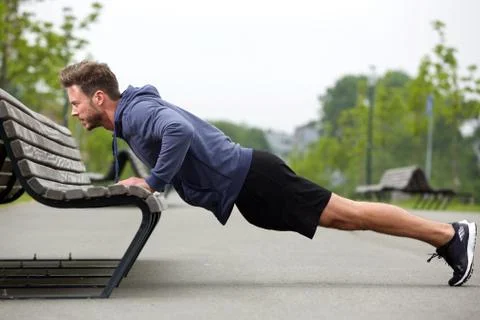Attractive man doing pushup outside Stock Photos