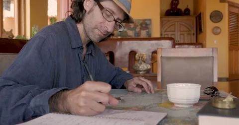 Attractive man doing research using a map and notebook Video stock 81476240