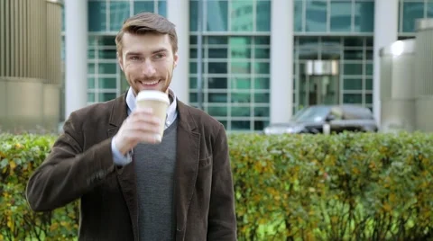 Attractive man drinking coffee or tea from paper cup, smiling Stock Footage 68402157