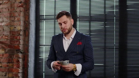 An attractive man in an expensive suit counts money. Calculates profit Stock Footage 170580326