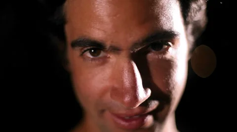 An attractive man grins at the camera on black 스톡 동영상 33876849