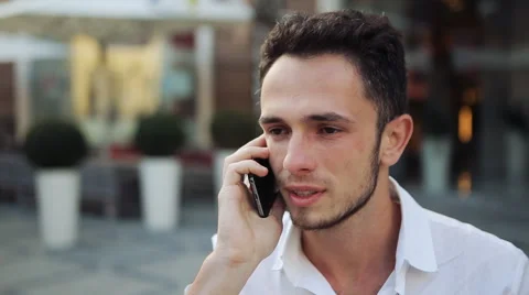 Attractive man holding on phone, listening and smiling. Young male  Stock Footage 59795800