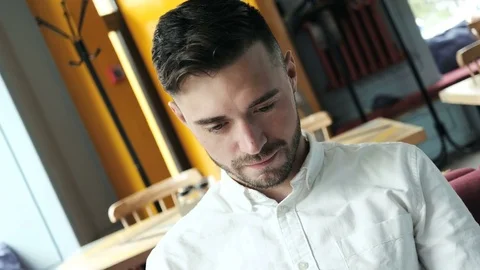 Attractive man looks at the camera and smiles. Shot with motion. Close up shot. Video stock 77000096