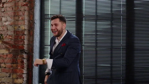 Attractive man in a nice suit laughs, has fun and shows thumbs up. Businessman Stock Footage 170579849